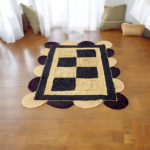 Handwoven scalloped jute rug with natural beige tones, showcasing wavy edges and textured fibers in a coastal-themed living room.